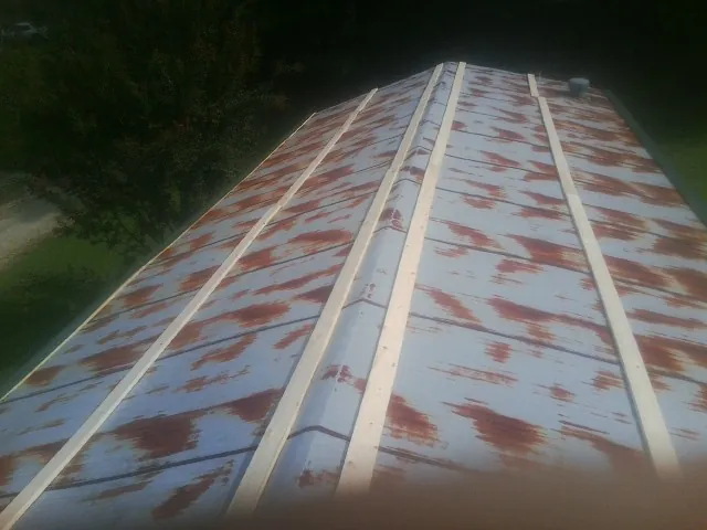 Rusted metal roof panels with new wood purlins before replacement — Storm Damage Roof Repair in Suwannee by Roofing Brothers